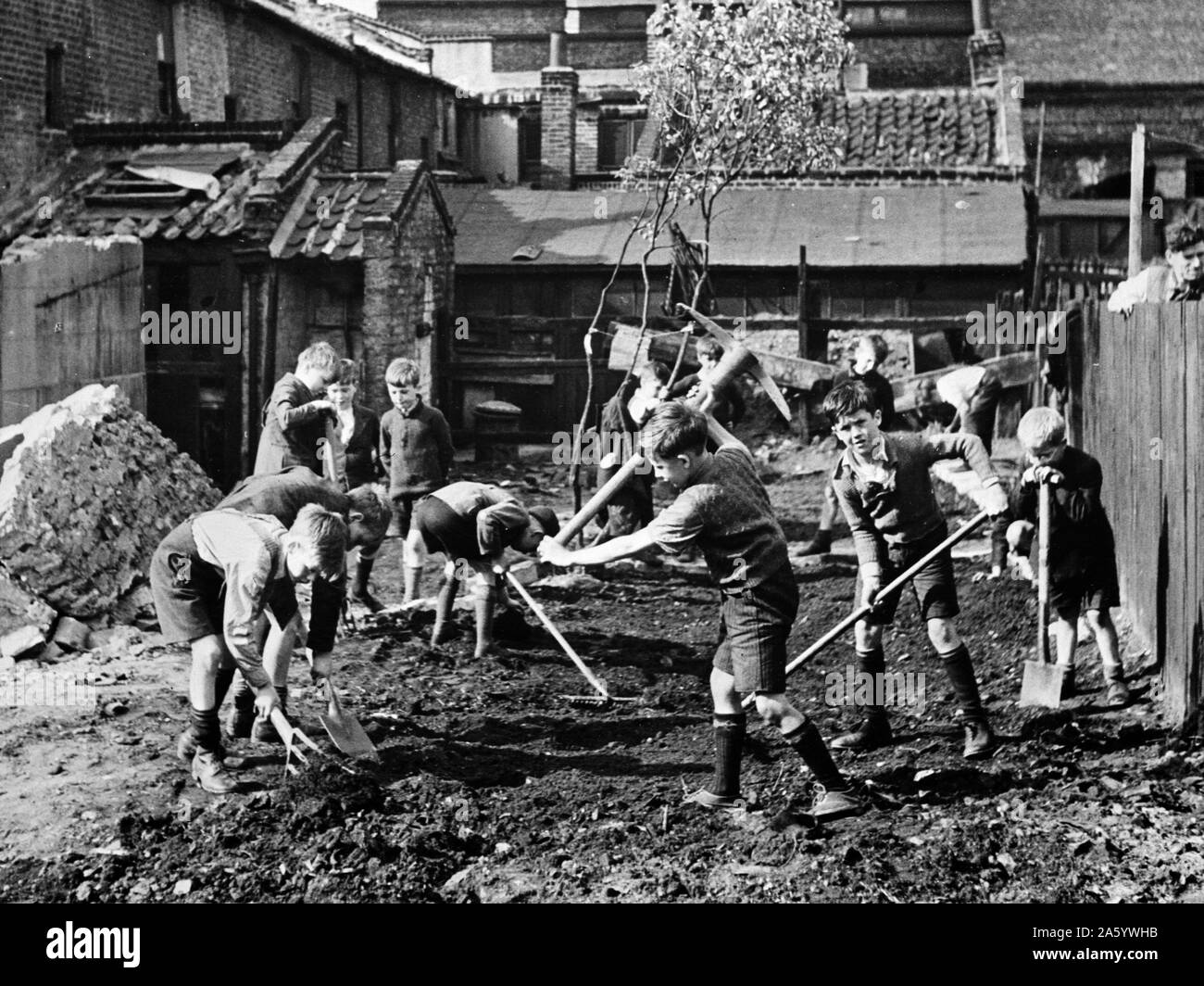 Ragazzi chiaramente via i detriti da una zona bombardato in Inghilterra, seconda guerra mondiale, 1943 Foto Stock