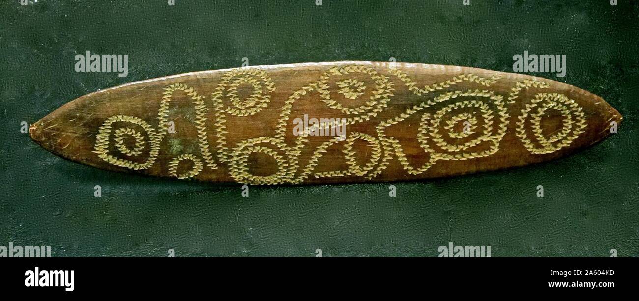 Arte Tribale: Aborigeni Australiani Churinga. Legno ovale scheda con segni sacri realizzati utilizzando un wallaby dente Foto Stock