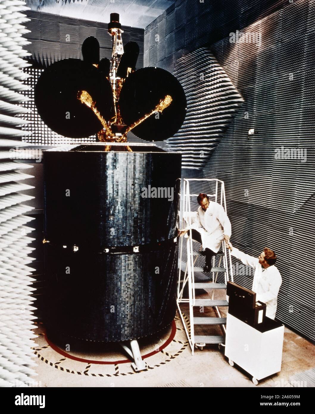 In una camera anecoica, ingegneri testando un Intelsat IV satellite di comunicazione, progettato dall'American aerospace company Hughes Aircraft Company. 1975 Foto Stock