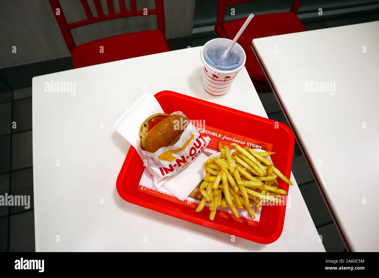 IN-N-OUT Burger - Hamburger e patatine fritte in un vassoio sul tavolo all'interno di un ristorante fast-food. Foto Stock
