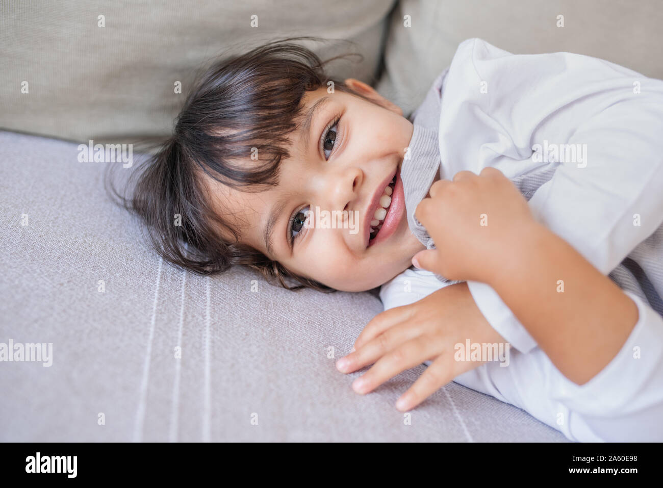 Adorabile bambina gioca sul suo soggiorno divano Foto Stock