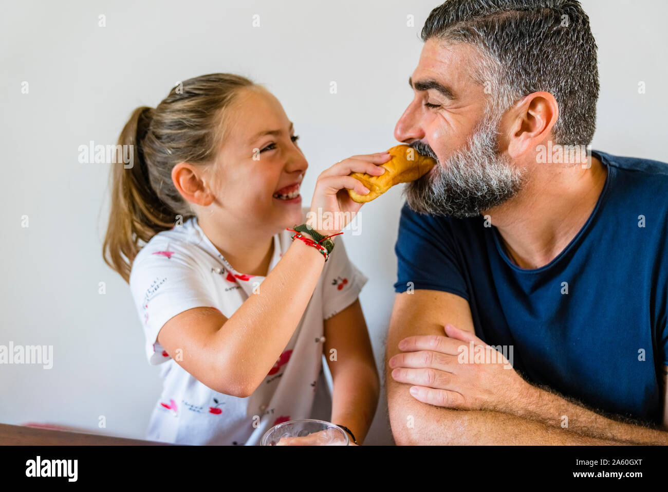Felice figlia padre di alimentazione a casa Foto Stock