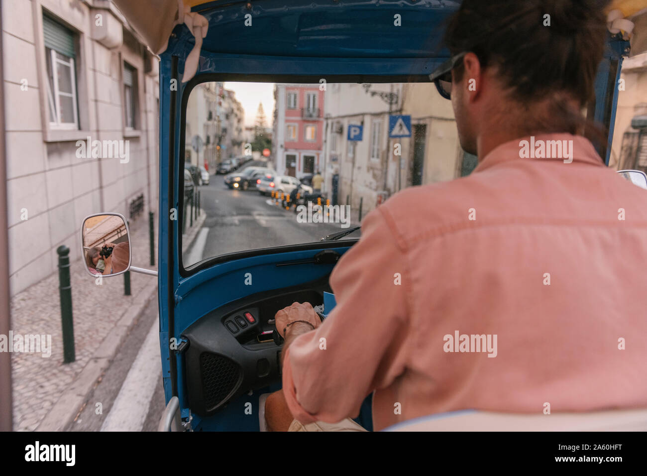 Vista da dietro di un tuk tuk driver nella città di Lisbona, Portogallo Foto Stock