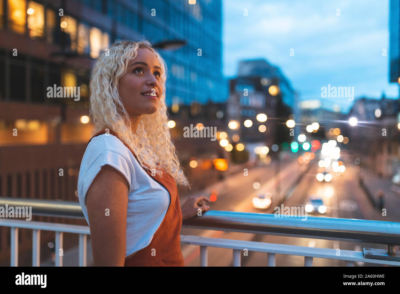 Giovane donna in città al tramonto con urban Street a Londra Foto Stock