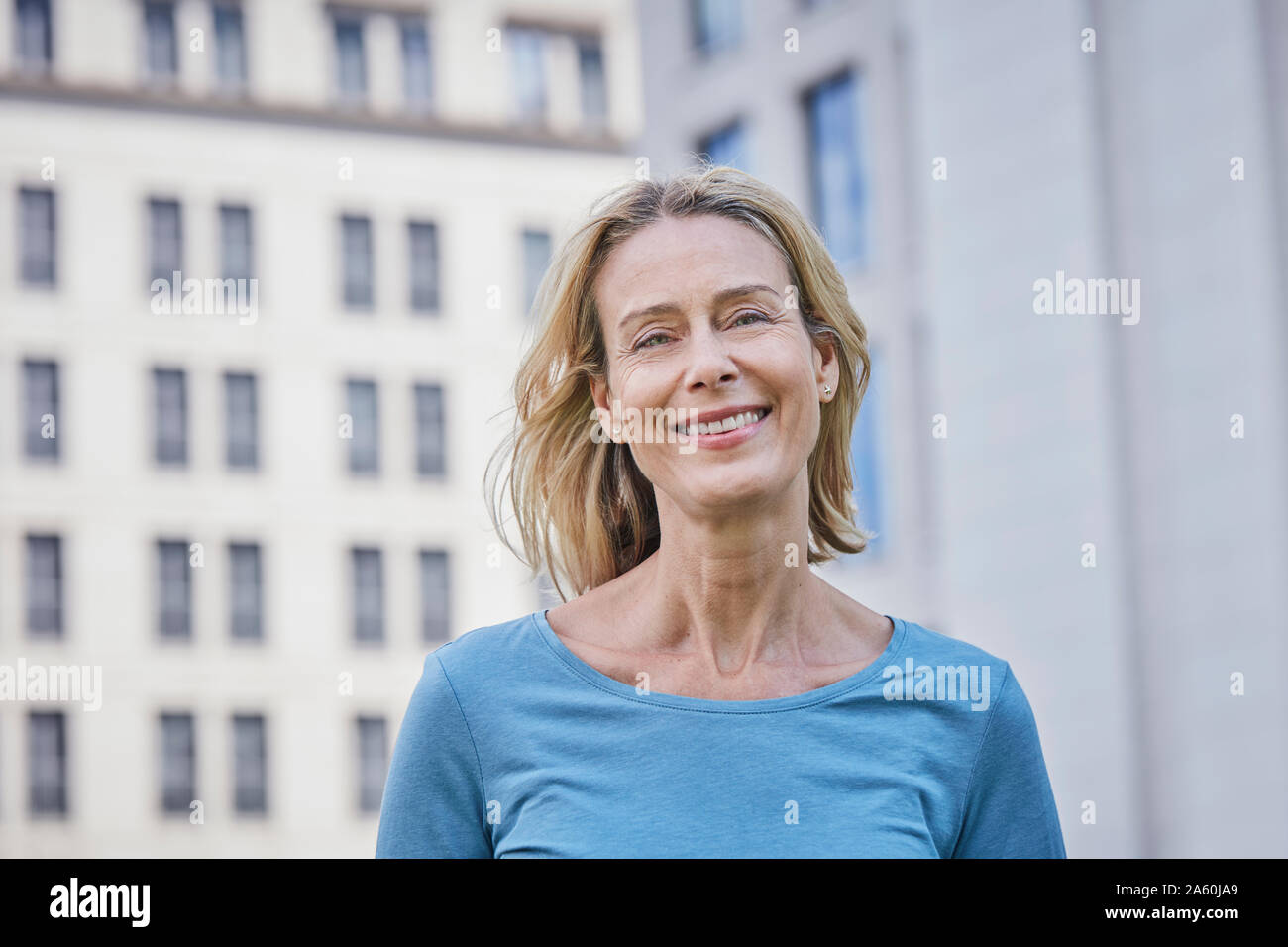 Ritratto di sorridere donna bionda nella città Foto Stock