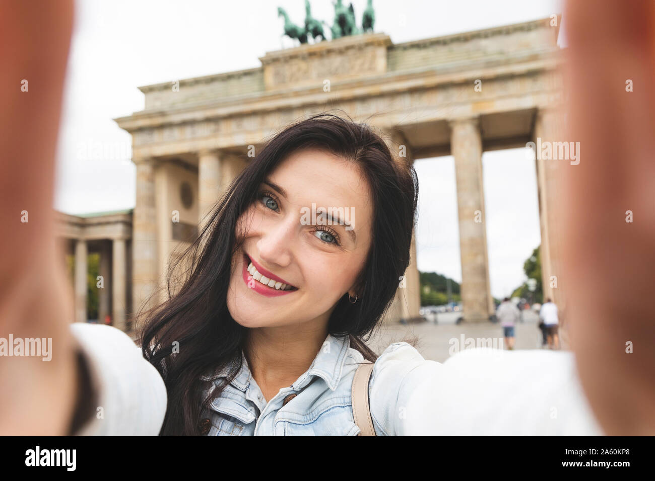Selfie di felice giovane donna alla Porta di Brandeburgo, Berlino, Germania Foto Stock