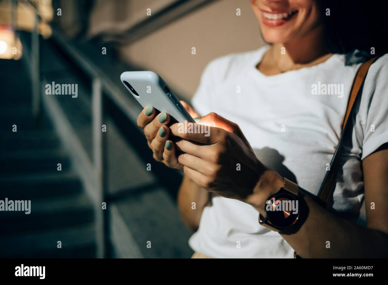 Giovane donna utilizza lo smartphone nella città di notte Foto Stock