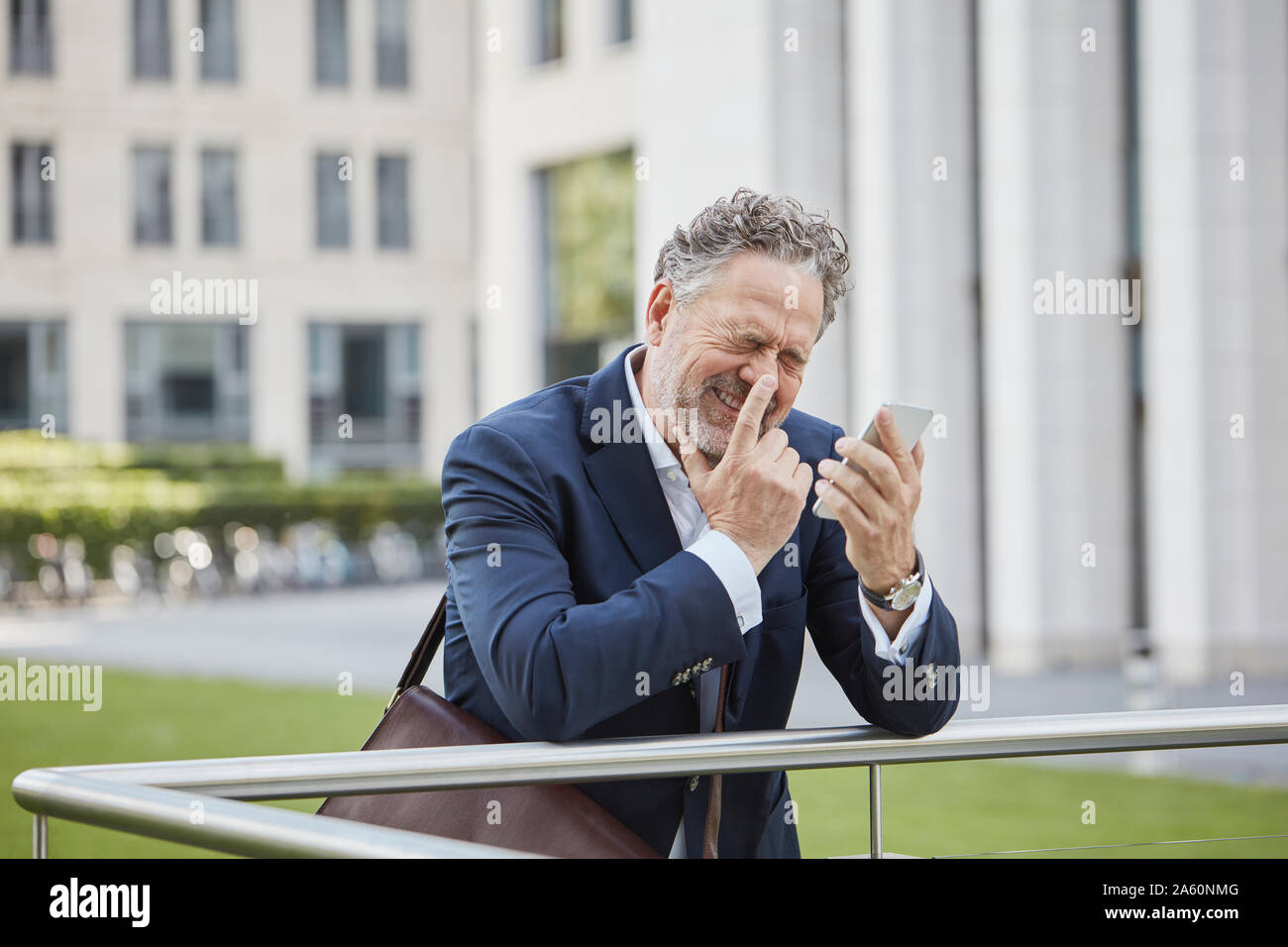 Happy businessman maturo con lo smartphone in città Foto Stock