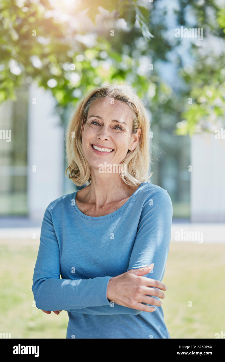Ritratto di sorridere donna bionda in un parco Foto Stock