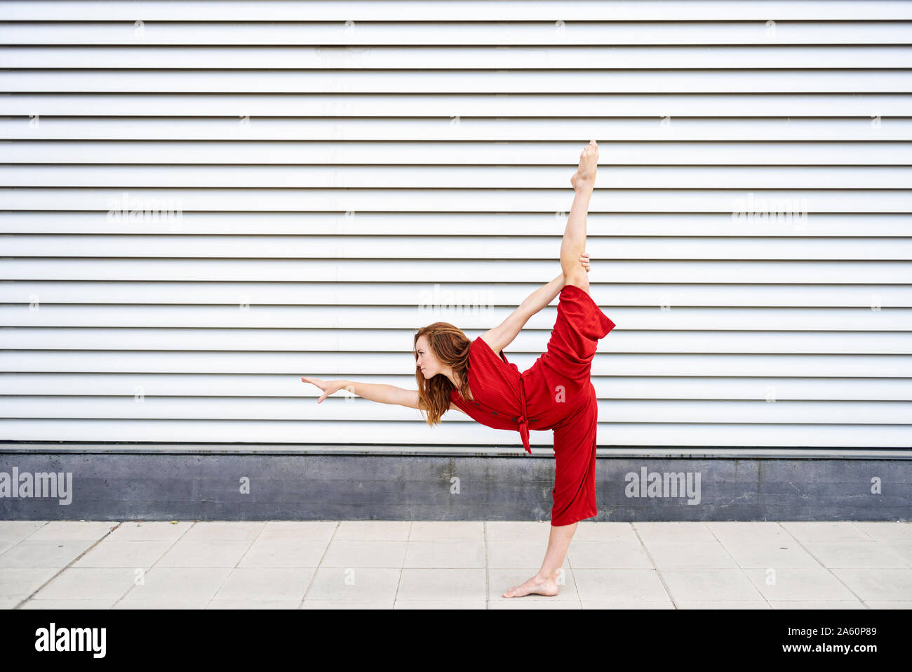Sporty giovane donna facendo acrobazie all'aperto Foto Stock