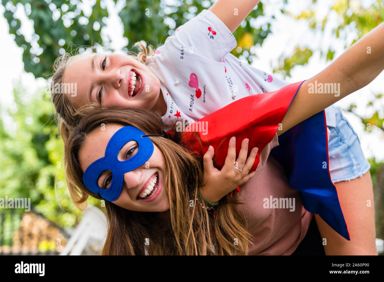 Due sorelle felice con occhio maschera giocando in giardino Foto Stock