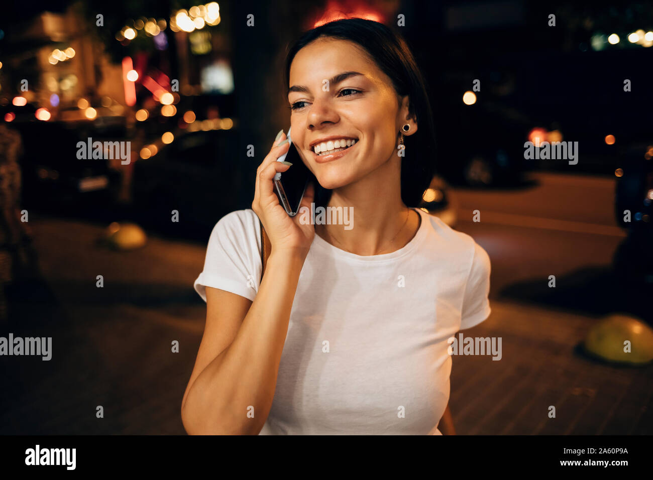 Giovane donna utilizza lo smartphone nella città di notte Foto Stock