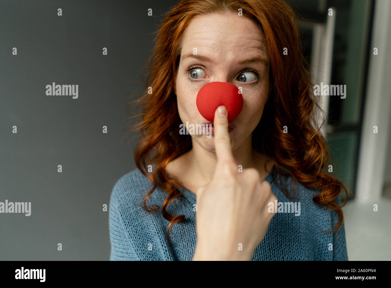 Ritratto di donna redheaded con clown naso Foto Stock