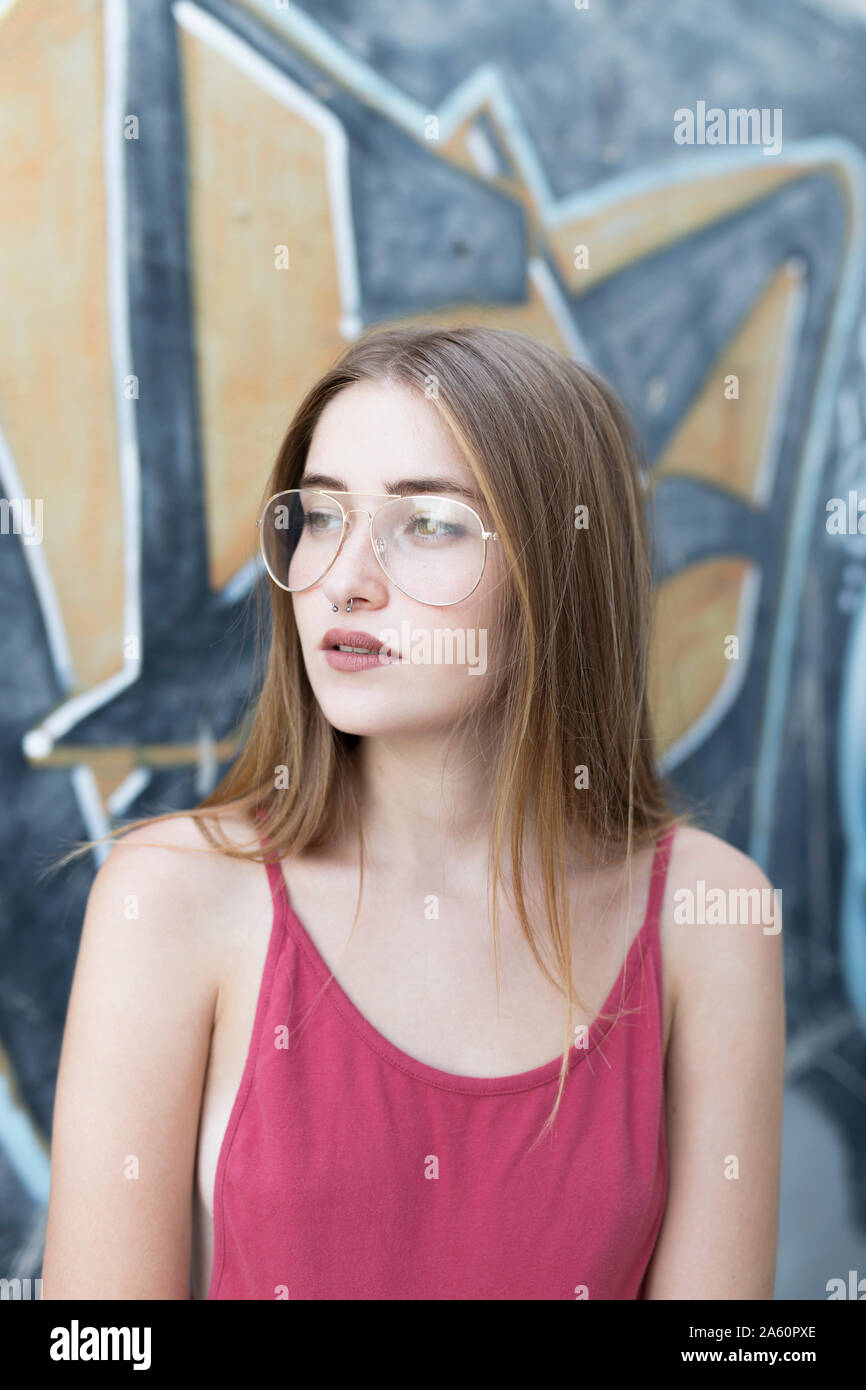 Ritratto di giovane donna di fronte a graffiti Foto Stock