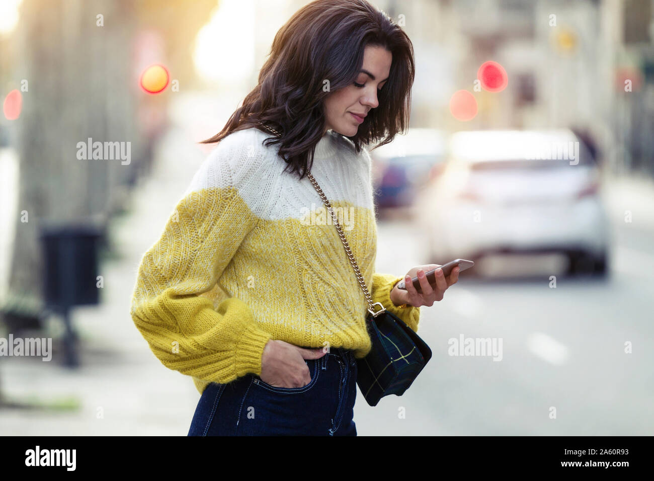 Brunette donna che usa il suo smartphone nella città Foto Stock