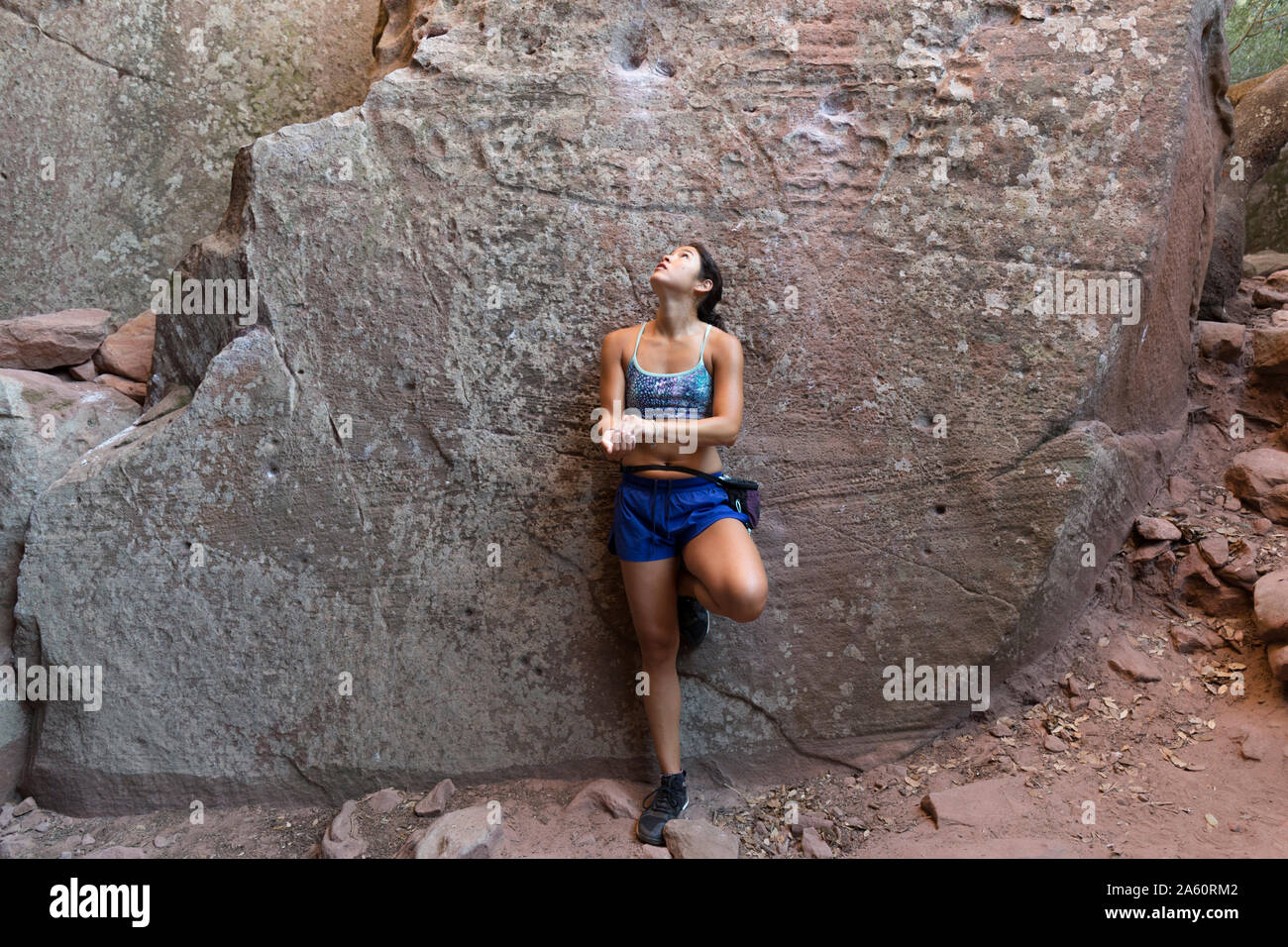 Giovane donna asiatica di arrampicata in una parete di roccia Foto Stock