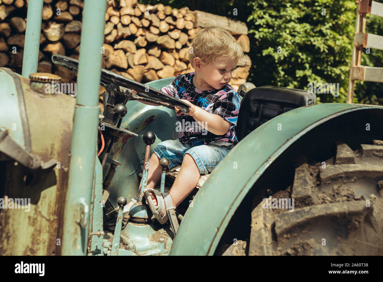 Little Boy fingendo di guidare un trattore Foto Stock