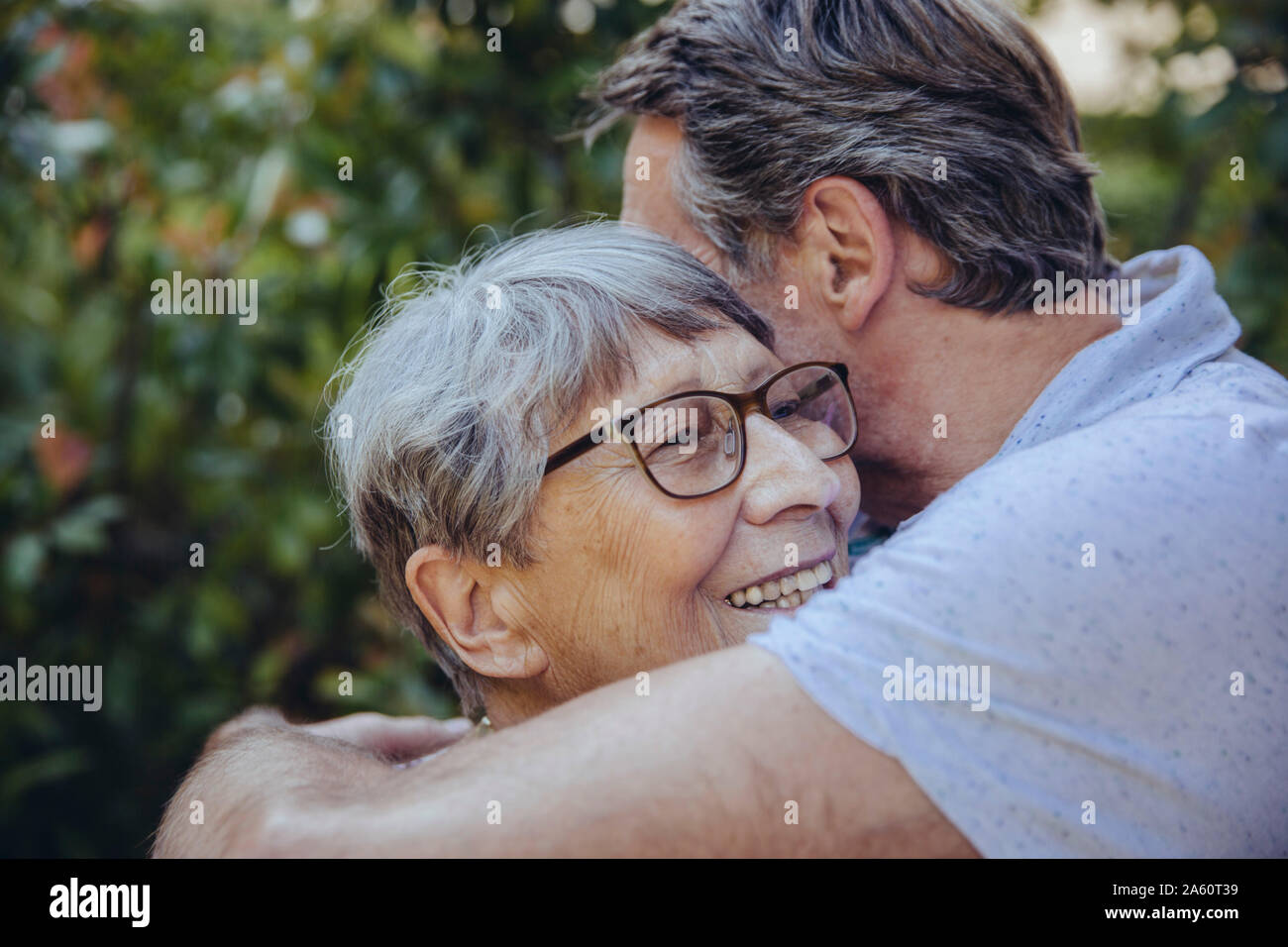Figlio adulto abbracciando la sua madre in giardino Foto Stock