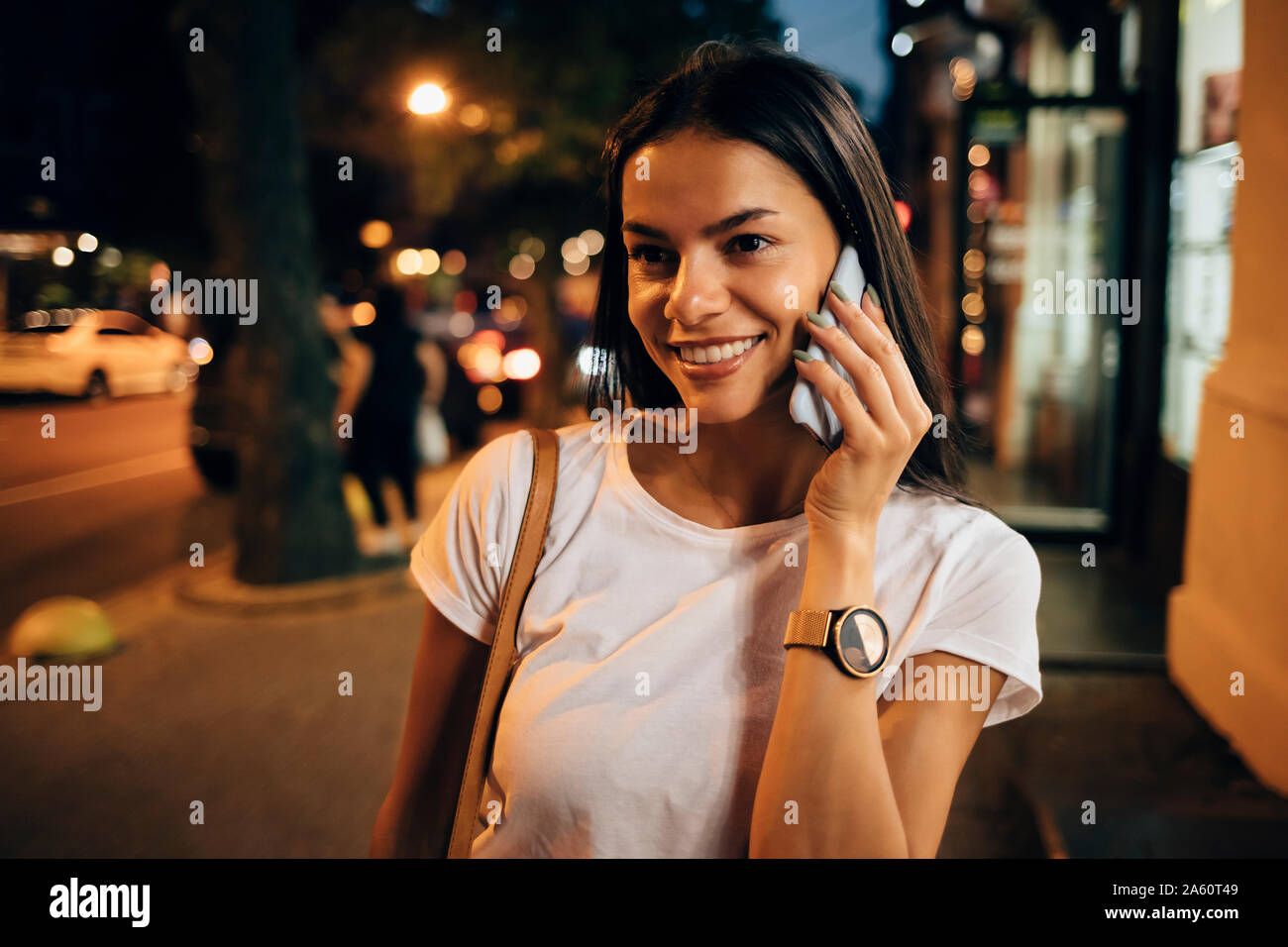 Giovane donna utilizza lo smartphone nella città di notte Foto Stock