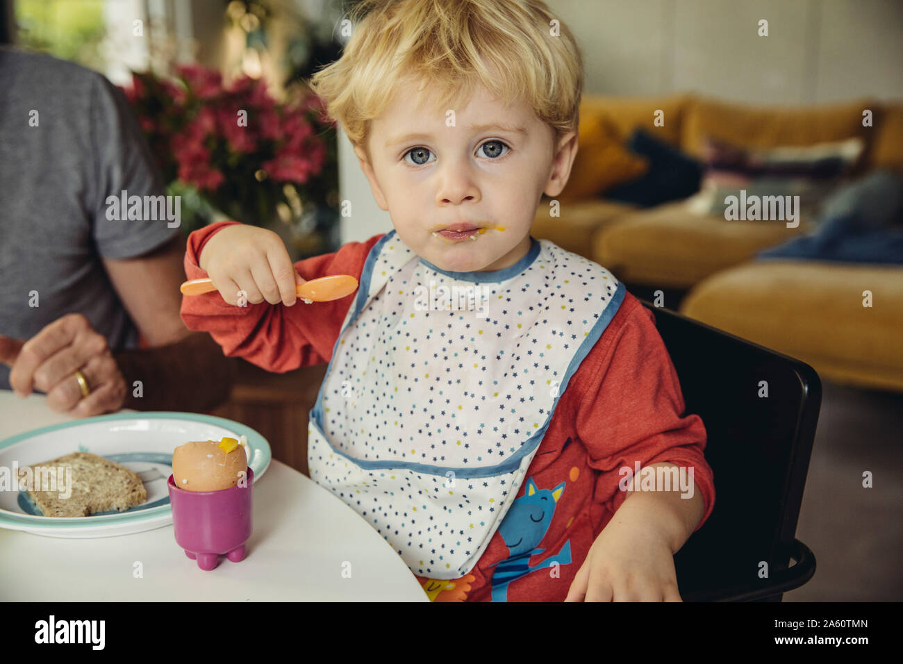 Ritratto del biondo ragazzino di mangiare la prima colazione uovo Foto Stock