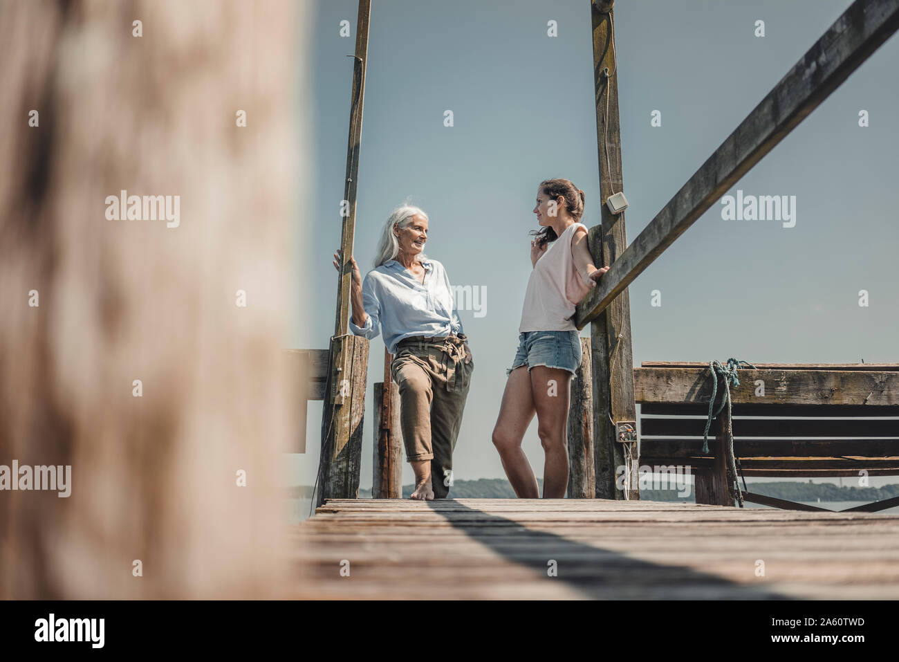 Madre e figlia in piedi sul molo, trascorrere una giornata al mare Foto Stock
