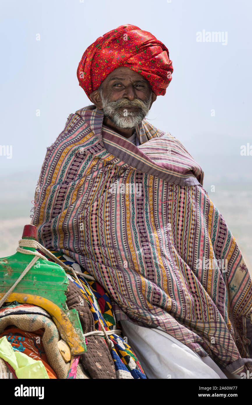 Uomo di Dhebariya Rabari comunità in stoffa tradizionale con un dromedario, grande Rann di Kutch deserto, Gujarat, India, Asia Foto Stock