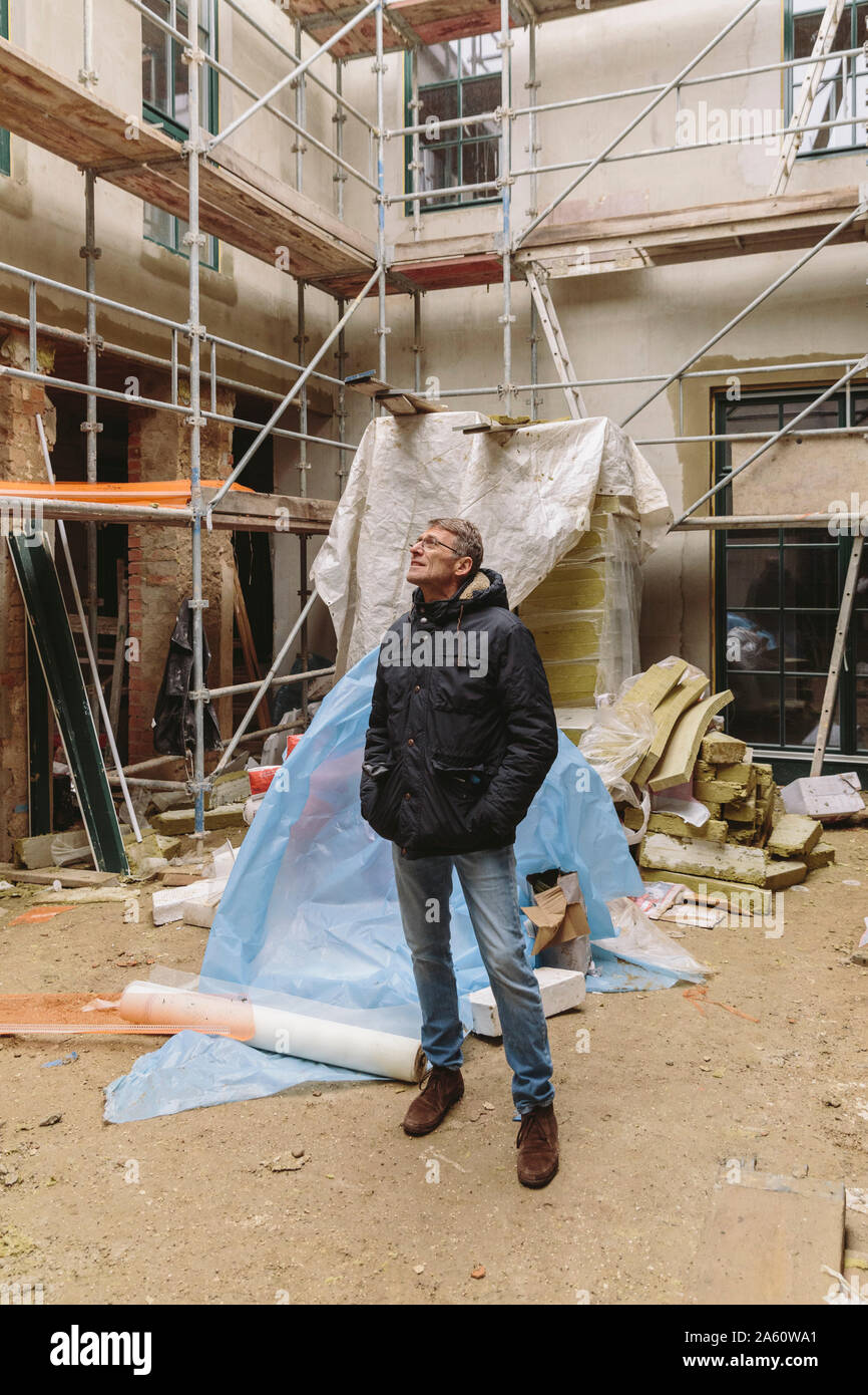 Uomo in piedi su un sito in costruzione Foto Stock