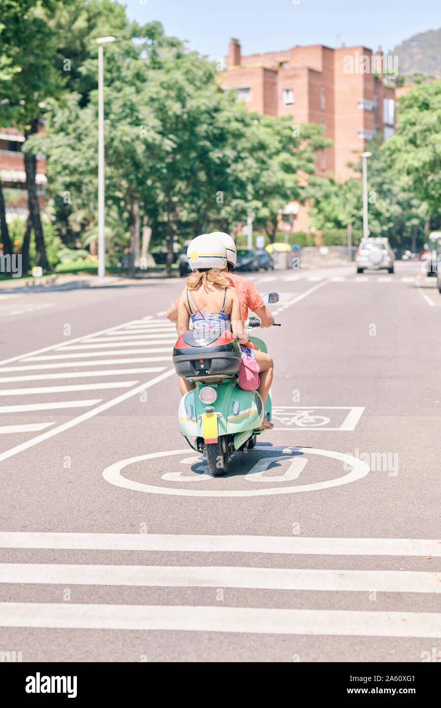 Coppia giovane in sella vintage scooter su strada urbana Foto Stock
