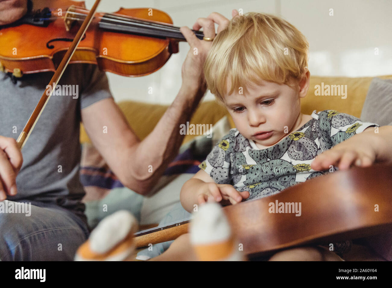 Ritratto di test toddler ukulele mentre suo padre suona il violino Foto Stock