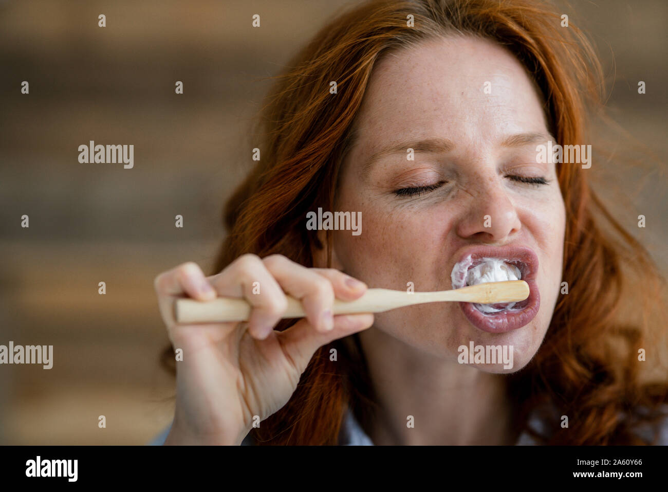 Ritratto di donna redheaded spazzolatura dei denti Foto Stock