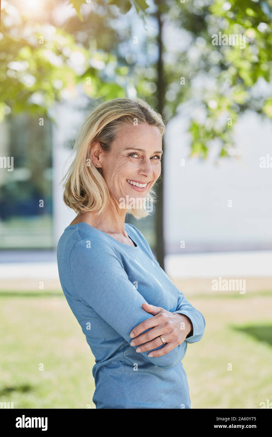 Ritratto di sorridere donna bionda in un parco Foto Stock