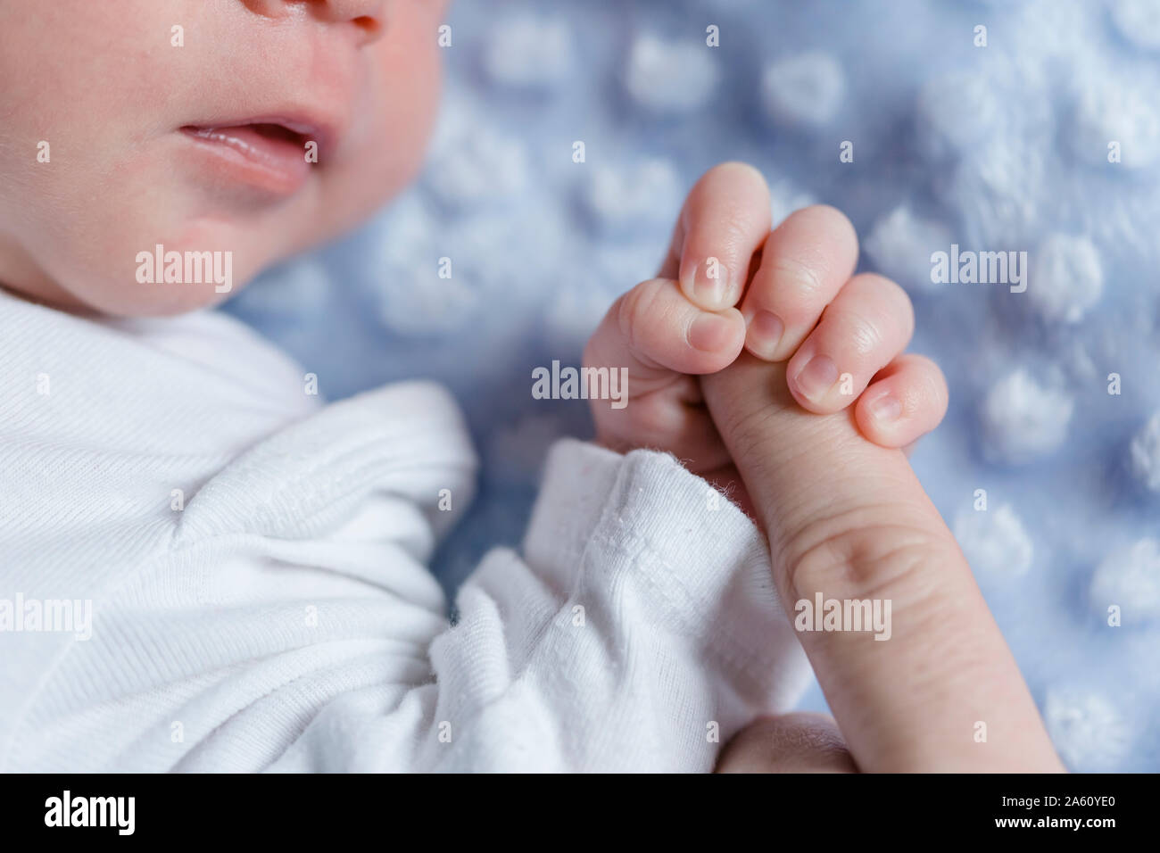 Neonato boy tenendo il dito Foto Stock