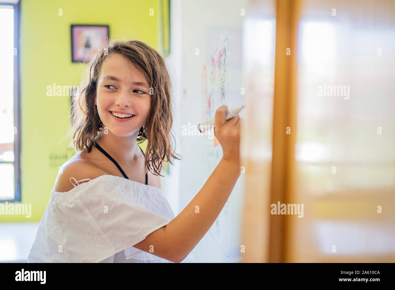 Ritratto di ragazza sorridente disegno su una lavagna bianca Foto Stock