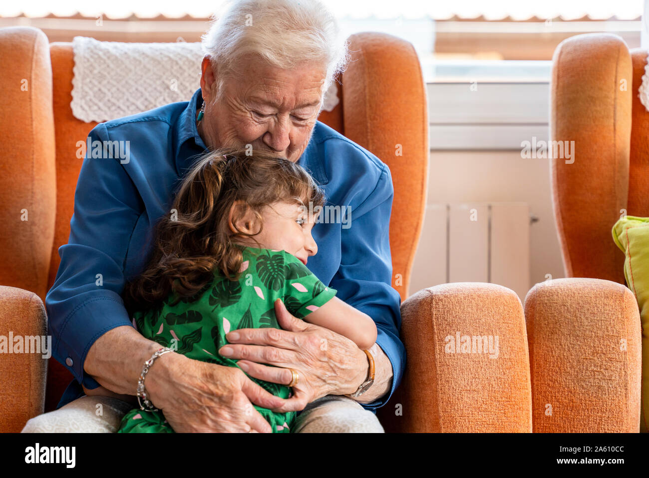 Nonna abbracciando il suo nipote in salotto Foto Stock