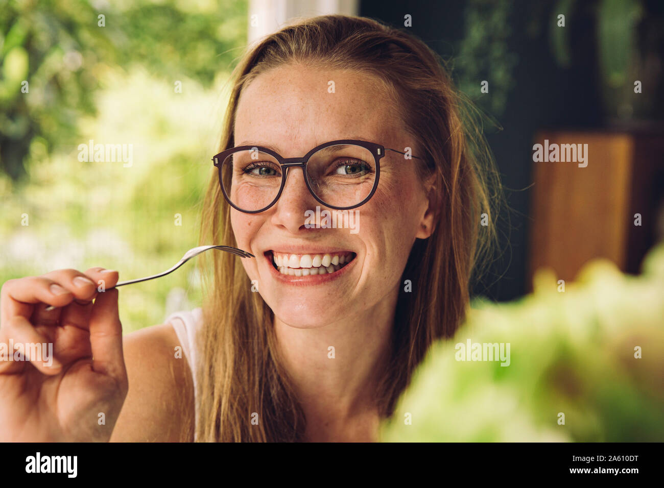 Ritratto di felice giovane donna con gli occhiali in possesso di una forcella Foto Stock