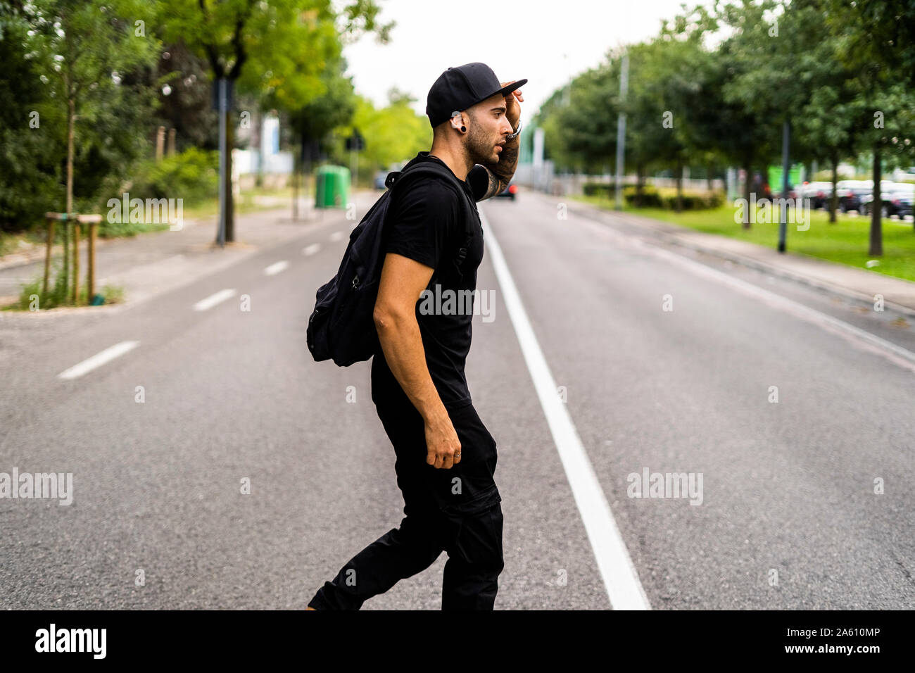Giovane con uno zaino di attraversare una via nella città Foto Stock