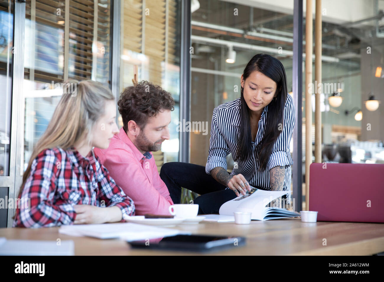 Business Casual persone aventi una riunione in un cafe Foto Stock