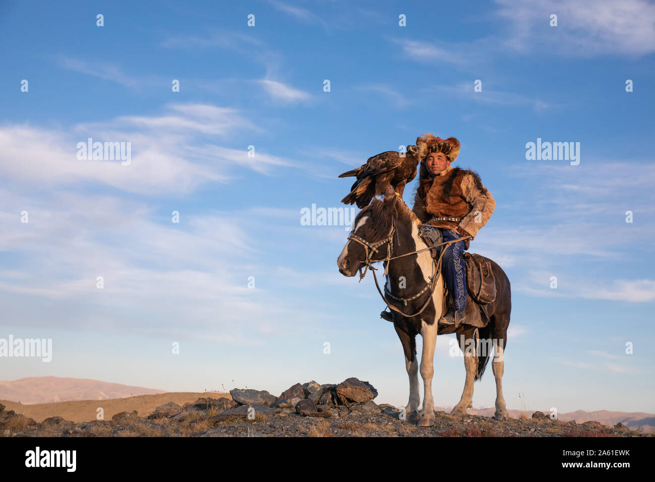 Ritratto di un tradizionale aquila kazaka cacciatore con il suo golden eagle e cavallo. Ulgii, Mongolia. Foto Stock