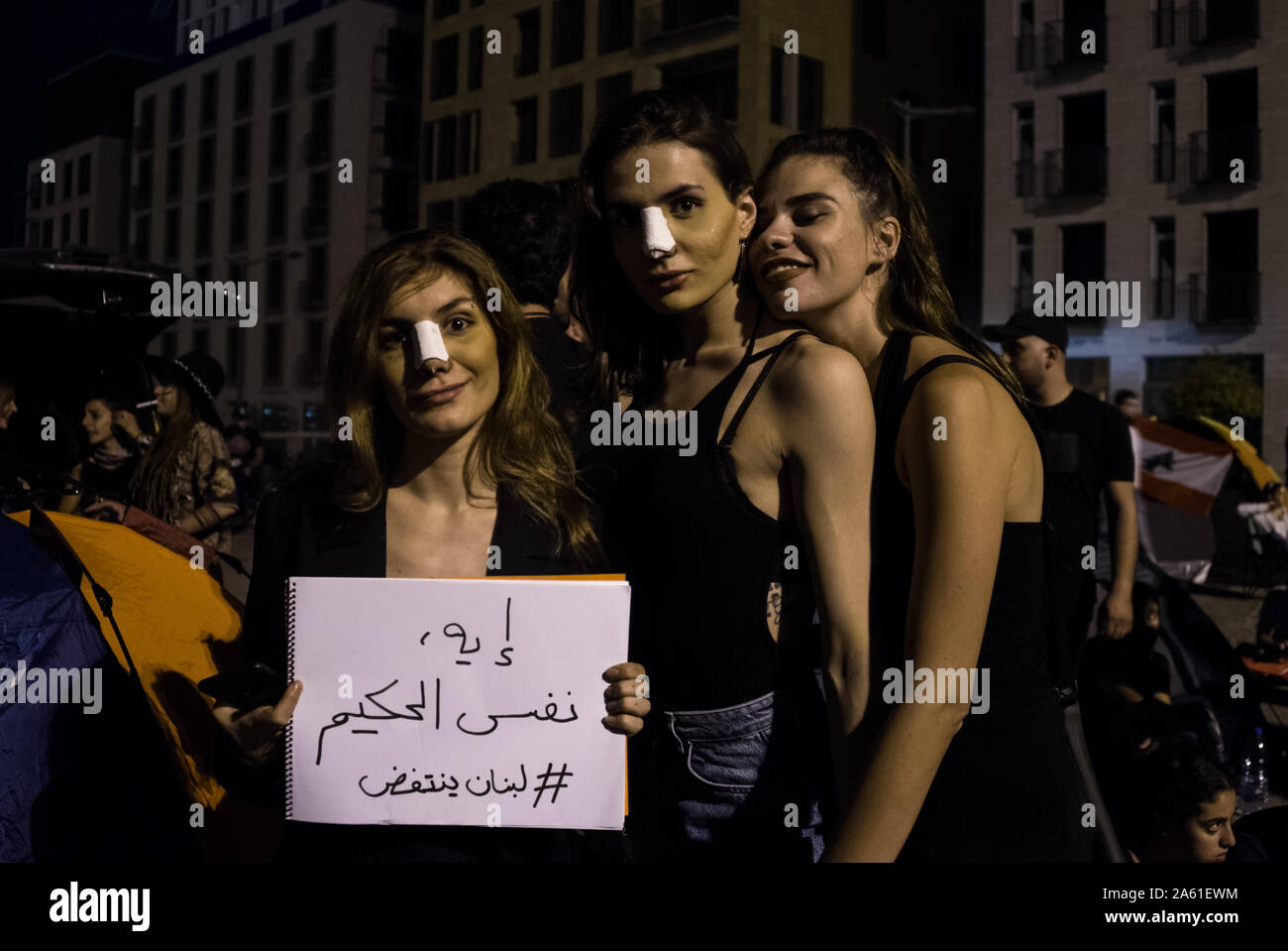 Donne manifestanti tenere un cartello recante la dicitura "Sì, abbiamo lo stesso chirurgo plastico' in Piazza Martiri, Beirut. I manifestanti a Beirut Libano dicono che non lascerà fino a quando tutto il governo si è dimesso. In tutto il paese simili raduni di massa si sono insediati in per i voli di lungo raggio come le persone si incontrano per un settimo giorno consecutivo. Uniti sotto una bandiera, questo multi-sect paese è che chiede di porre fine al suo governo settario e la punizione per la corruzione è stata soggetta a per 30 anni. Foto Stock