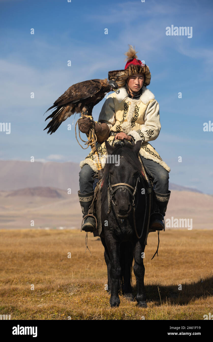 Ritratto di un tradizionale aquila kazaka cacciatore con il suo golden eagle e cavallo. Ulgii, Mongolia. Foto Stock