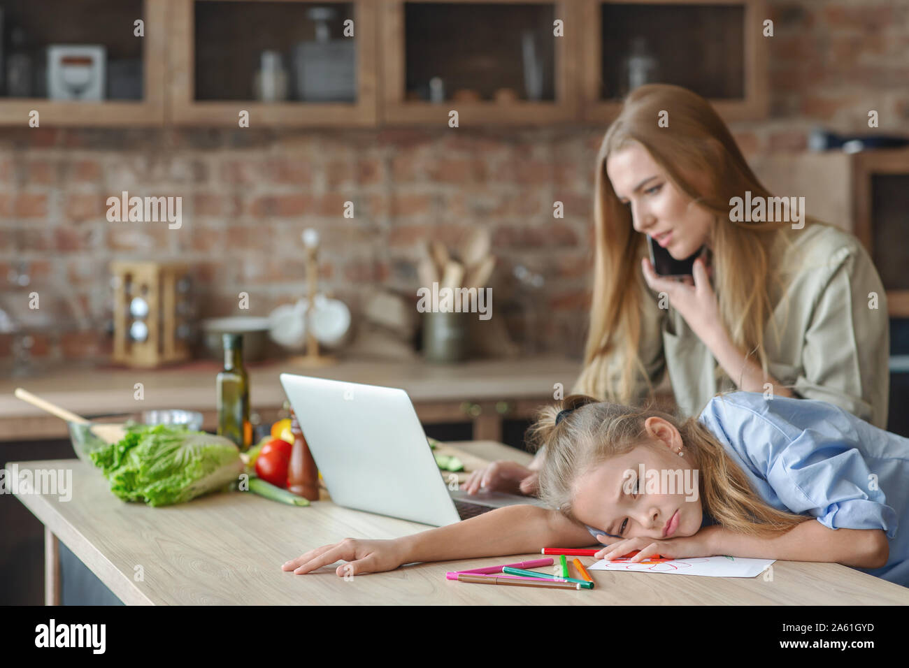 Triste bambina sensazione annoiarsi mentre la madre lavora da casa Foto Stock