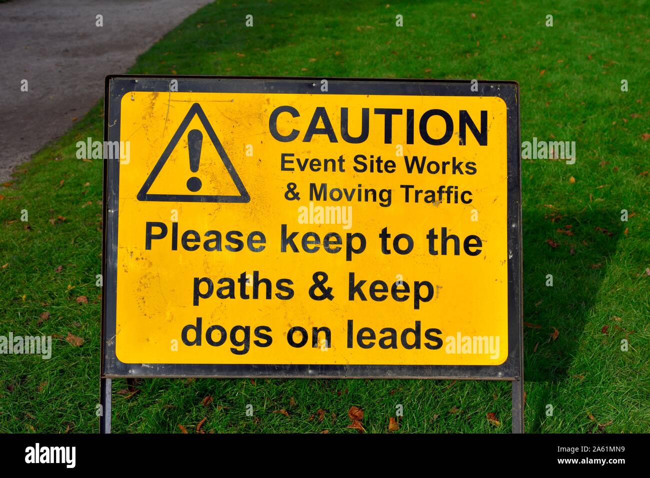 Giallo segno di attenzione,si prega di mantenere i percorsi,tenere cani su fili,evento sito funziona,il traffico in movimento Foto Stock