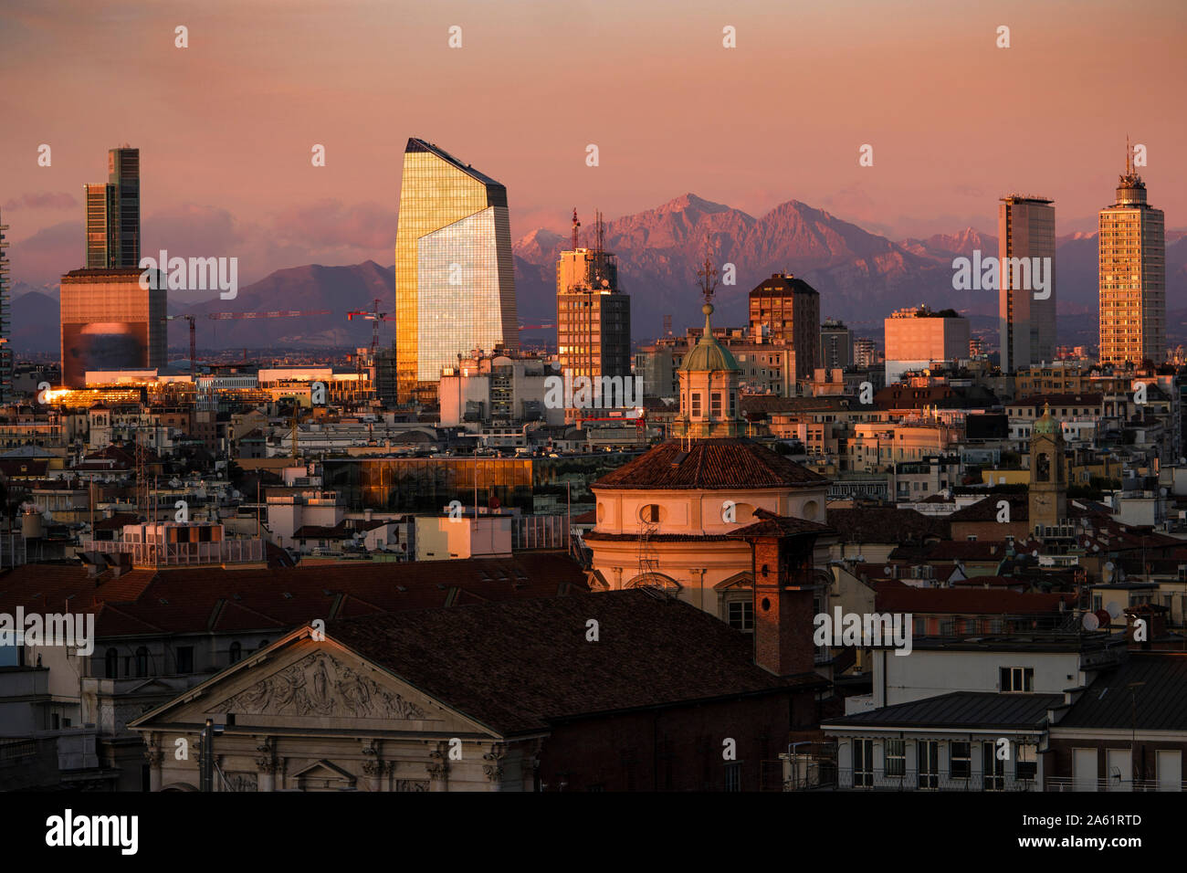 Lo skyline di Milano con grattacieli al tramonto. Vista aerea della città di Milano, Italia. Le Grigne mountain range (Lombardia Alpi) in background. Foto Stock