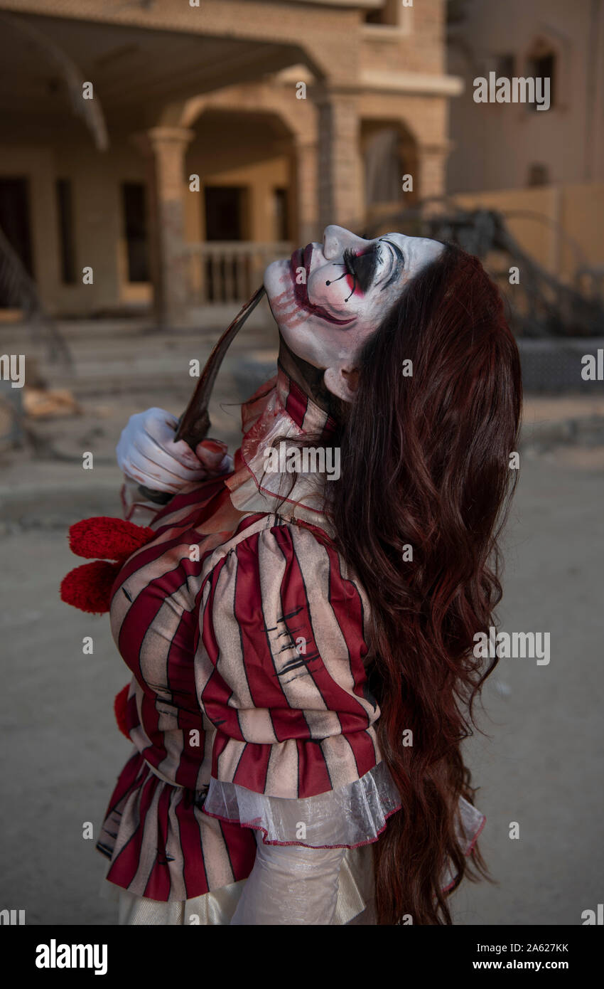 Un ritratto di un arrabbiato pazzo clown ragazza in casa di caccia. Concetto di Halloween tema Foto Stock