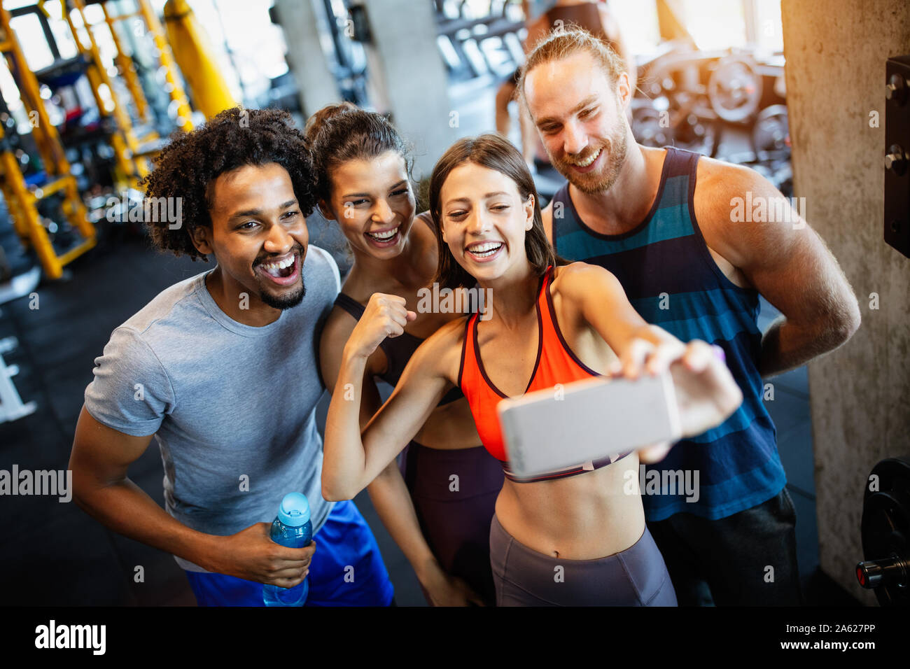 Gruppo di persone sportive in una palestra tenendo selfie. Concetti relativi allo stile di vita e sport nel fitness club Foto Stock