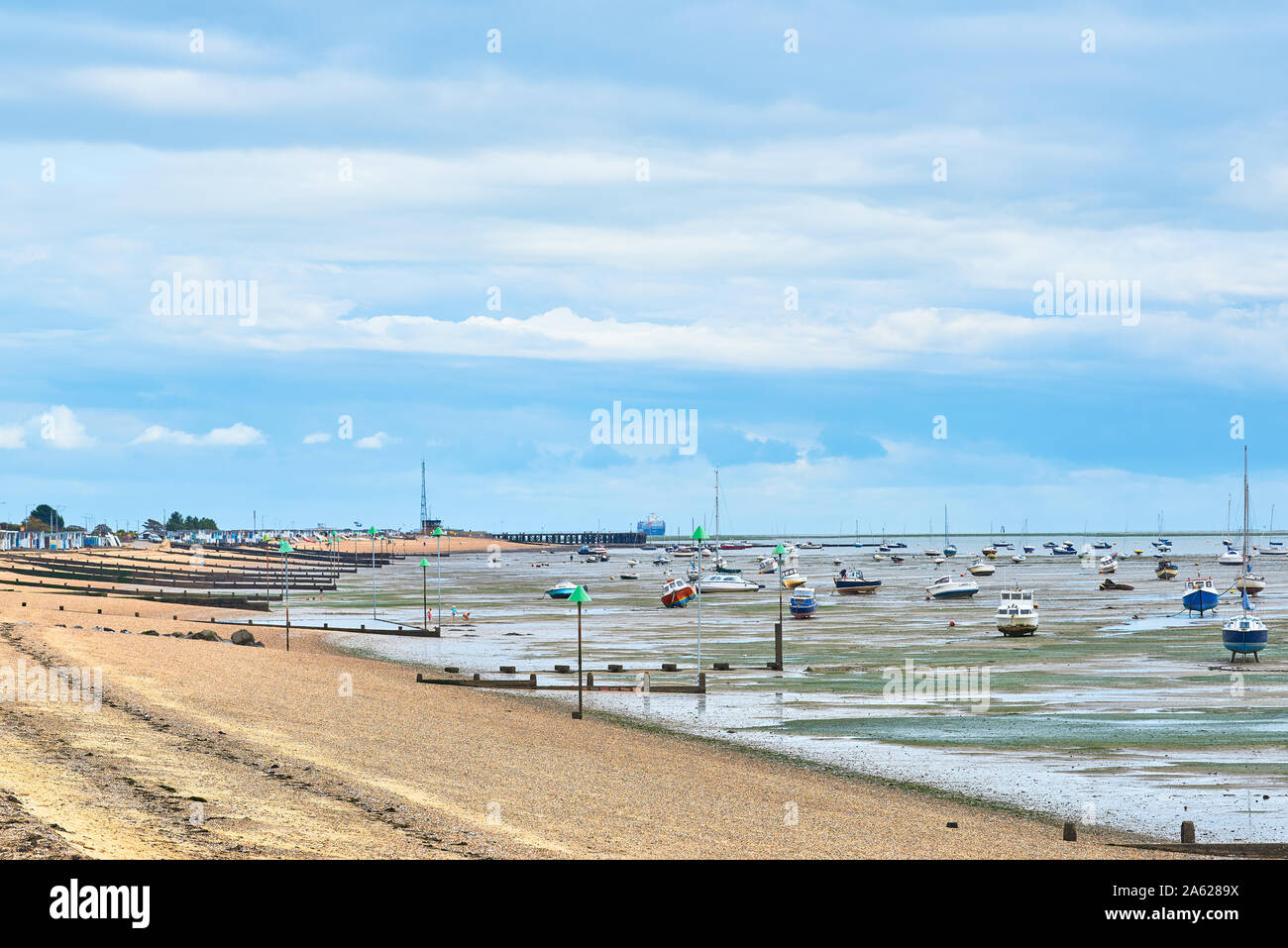 Di ghiaia e sabbiosa spiaggia accanto il fango appartamenti del fiume Thames Estuary a Thorpe Bay, Southend-on-Sea, Essex, Inghilterra. Foto Stock