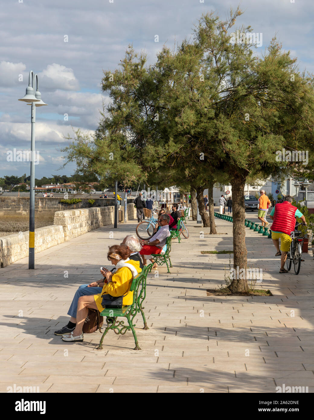 La flotte e Harbour, Ile de Re, Francia. Il turista a godere il sole pomeridiano sul lungomare. Foto Stock