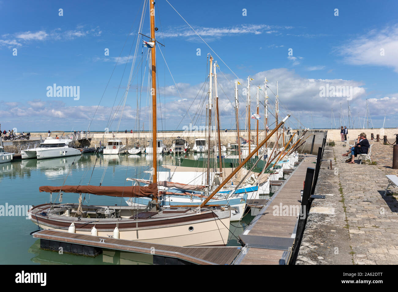 La Flotte Harbour, Ile de Re, Francia. Lo stile tradizionale di imbarcazioni da diporto moor fino a prua con il bowsprits sollevato in modo da occupare meno spazio di ormeggio Foto Stock