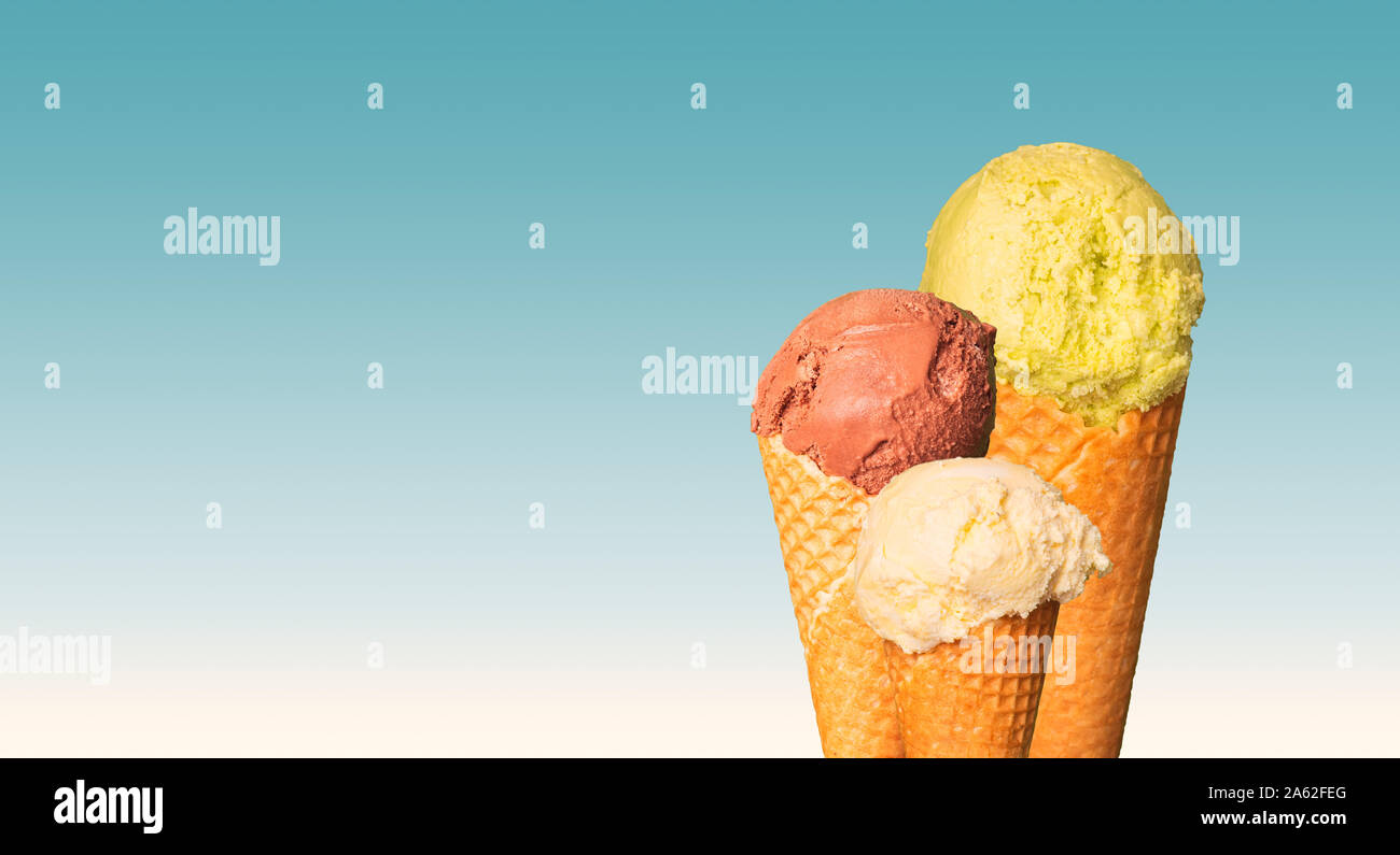 Palline di gelato su sfondo blu. Dolce con in coni. Il ghiaccio naturale la crema di cioccolato, pistacchio e vaniglia o crema di sapore. Libera co Foto Stock