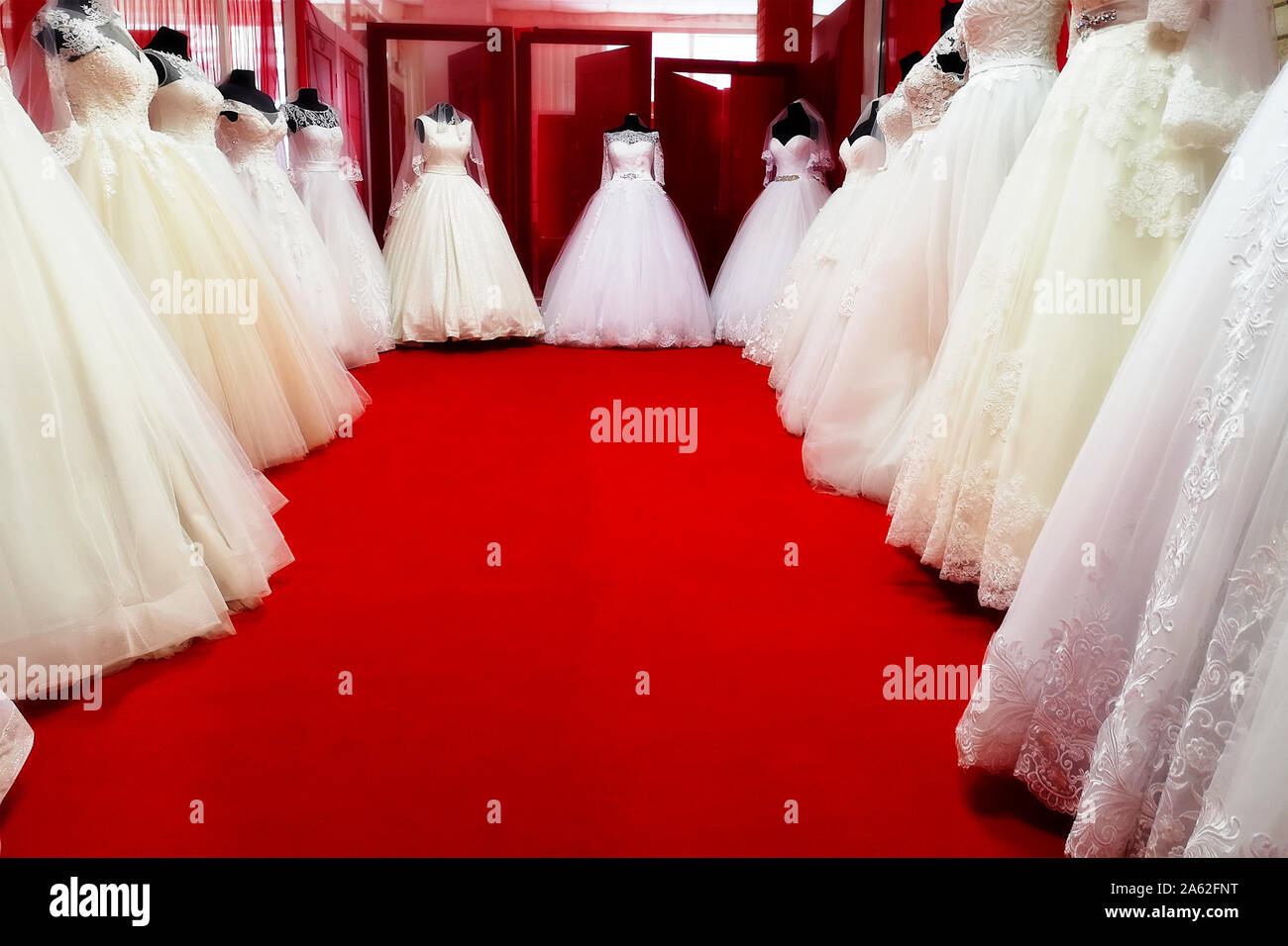 Collezione di Abiti da sposa nel negozio. Abiti da sposa in un negozio. Bellissimi abiti da sposa su manichini. Foto Stock